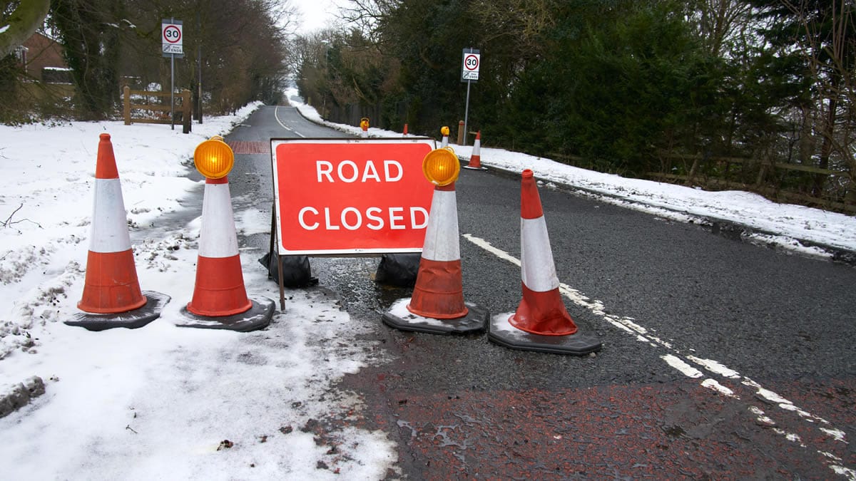 Photo of a road closed sign in the snow